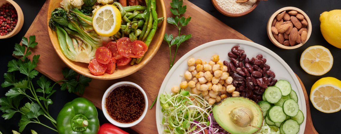 Vegan protein source. Buddha bowl dish, avocado, pepper, tomato, cucumber, red cabbage, chickpea, fresh lettuce salad and walnuts, nuts, beans, . Healthy vegetarian eating, super food. Top view.